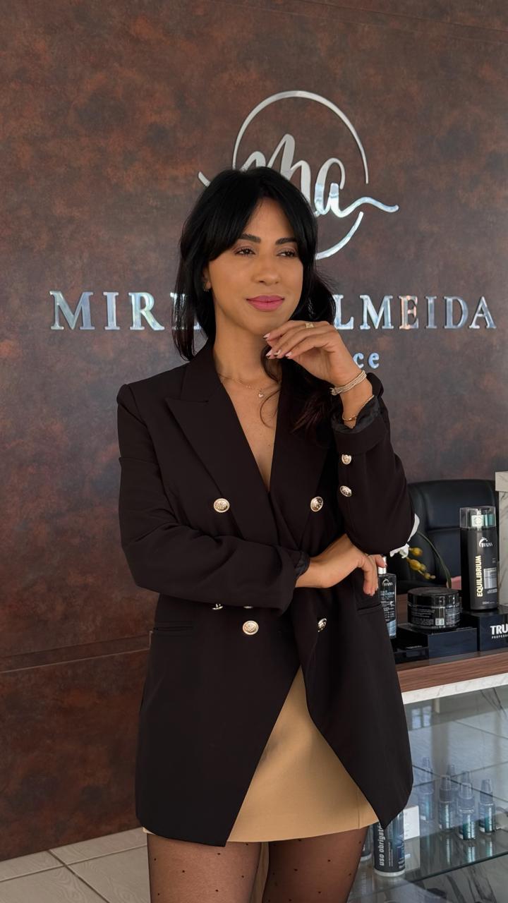 Miriam Almeida no estúdio, com a marca ao fundo